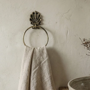 Vintage bronze shell towel ring on a textured wall for rustic bathroom decor