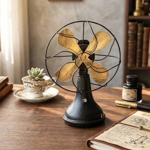 Vintage industrial metal desk fan with golden blades on a wooden office desk