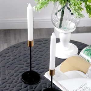 Modern Nordic black and gold metal candle holder set on a textured dining table
