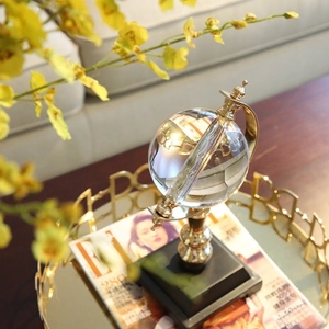Luxury crystal globe desk ornament with gold metal stand on a decorative tray