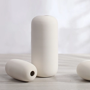 Set of minimalist white ceramic vases with ribbed texture for modern home decor