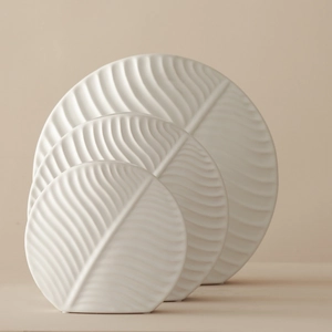 Set of three white ceramic leaf-shaped vases with detailed vein textures for home decor