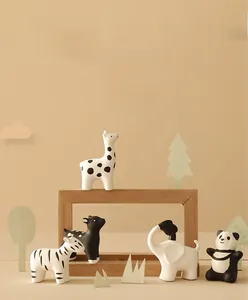 Handcrafted matte ceramic animal figurines featuring panda, elephant and giraffe designs