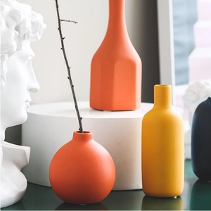 Vasi moderni in ceramica Morandi arancio e giallo opaco su un supporto bianco minimalista