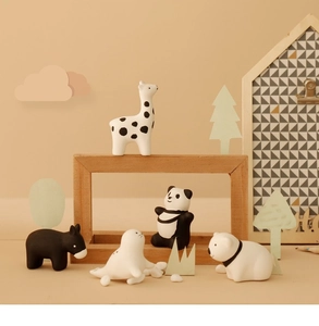 Detailed view of 5 mini ceramic animal figurines like giraffe and panda on wood decor