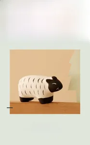 Detail of cute ceramic sheep figurine with wavy wool textures on a natural wood base