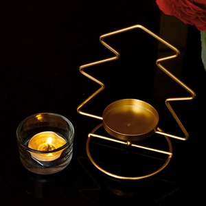 Noorse gouden metalen kandelaar in kerstboomvorm op een zwart reflecterend oppervlak