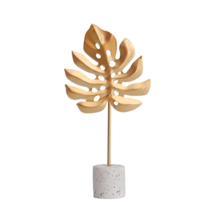 Nordic gold metal monstera leaf ornament with a white terrazzo base for home decor