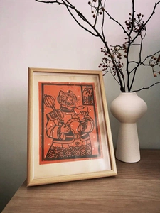 Detail eines Holzrahmens mit Comic-Tiger und Goldbarren auf einem schicken Schreibtisch