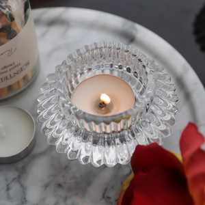 European fluted glass candle holder with tea light candle on white marble tray