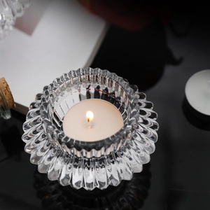 European minimalist glass candle holder with ribbed solar flare design and lit tea light