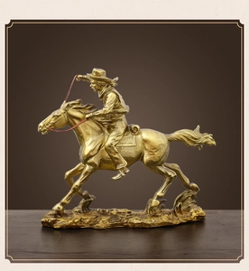 Detailed close-up of antique gold cowboy rider sculpture with intricate metallic textures