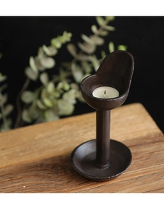 Close-up of vintage cast iron candle holder with tea light on a wooden table surface