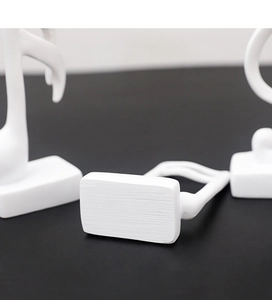 Macro close-up of matte white resin musical note sculpture with textured base detail