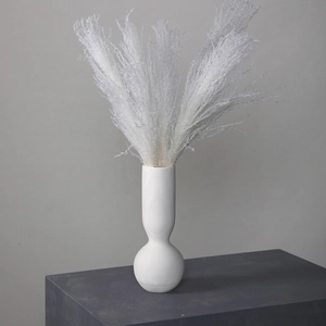 Minimalistische weiße Keramikvase mit Streifen und Trockengras auf geometrischem Ständer
