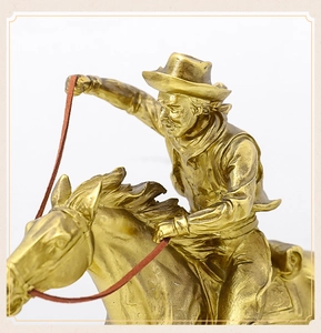 Detailed side view of golden resin cowboy statue on horse for luxury home decor