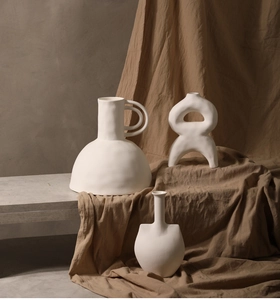 Detail von mattweißen Keramikvasen mit Ringgriffen und abstraktem geometrischem Kunstdesign