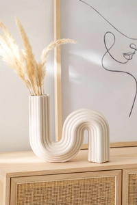 Détail du vase en céramique en S avec textures verticales et décor d'herbe de la pampa