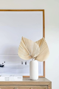 Close-up of dried palm leaves in a white matte vase for minimalist home decor