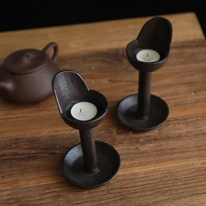 Set of two vintage cast iron candle holders on wooden table for home decor