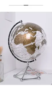 Close-up of a luxury glowing transparent globe with golden map on a metal tripod base