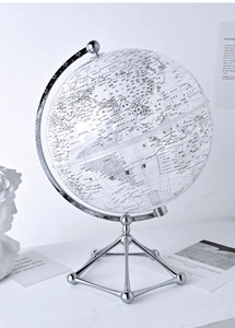 Detail of transparent globe with silver metal tripod stand on a luxury office desktop