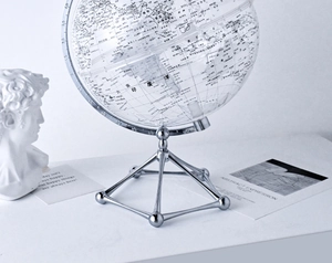 Macro detail of transparent globe sphere with silver metal tripod stand on a desk