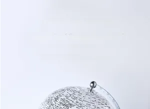 Macro shot of silver metal world globe with detailed geographic markings and meridians
