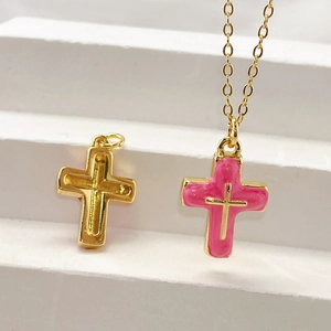 Gold-plated cross pendant necklace with pink enamel marble finish on white display