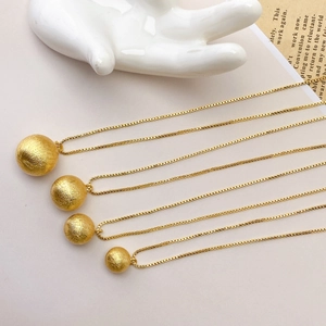 Detail view of hollow brushed golden copper beads on a box chain for DIY jewelry