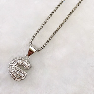 Macro detail of silver letter G pendant necklace with sparkling cubic zirconia inlay
