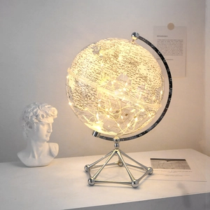 Modern transparent glowing globe with warm LED lights and silver metal stand for home decor