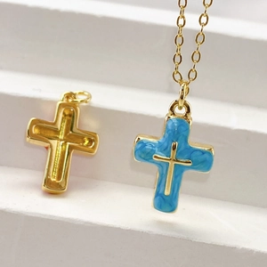 Detail showing the front and back of a gold cross pendant with blue marble inlay