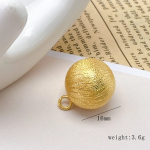 Detailed macro view of a 16mm golden brushed hollow copper bead pendant for DIY jewelry