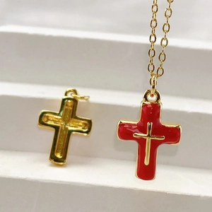 Detail showing red enamel cross pendant with gold-plated metal base on an O-chain necklace