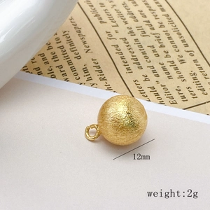 Macro shot of 12mm hollow brushed gold copper bead pendant with 2g weight details