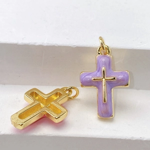 Detail of colorful cross pendants with gold plating and purple enamel finish