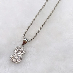 Macro shot of silver letter S pendant necklace encrusted with shimmering cubic zirconia