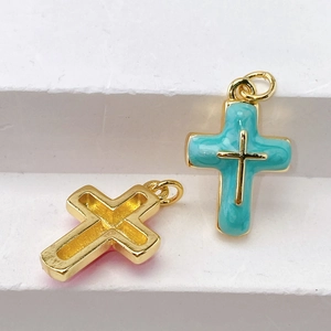 Macro shot of gold-plated cross pendants with turquoise enamel and small gold details