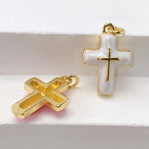 Macro shot of gold-plated cross pendants with white enamel inlay for DIY jewelry