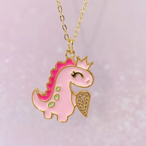 Makroaufnahme von rosa Dino-Anhänger mit Herz-Zirkonia-Detail und Goldkrone
