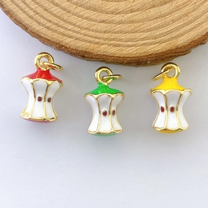 Detailed macro view of enamel apple core pendants in red green and yellow plated alloy