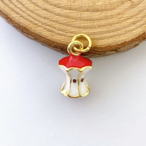 Macro shot of a creative apple core pendant with red enamel and golden apple seed details