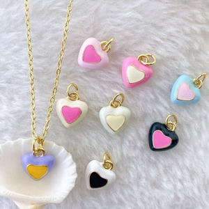 Detailed macro view of colorful enamel heart pendants with gold-plated metal borders
