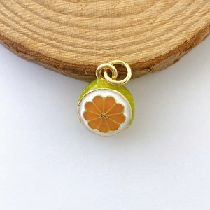 Detailed view of orange slice pendant with vibrant enamel finish and gold jump rings