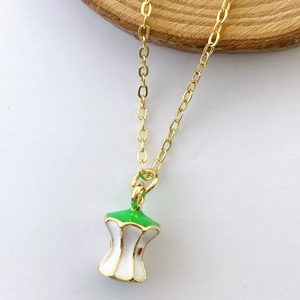 Detailed close-up of a creative gold enamel apple core pendant on a delicate chain necklace