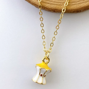 Close-up of creative apple core pendant necklace with colorful enamel on gold chain