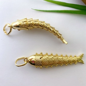 Articulated koi fish pendant in gold-plated brass with red gemstone eyes and moving joints