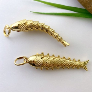 Detail shot of flexible golden koi fish pendant with intricate scales and movable joints