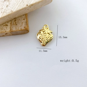 Macro view of gold strawberry charm with 15.5mm size and realistic seed texture